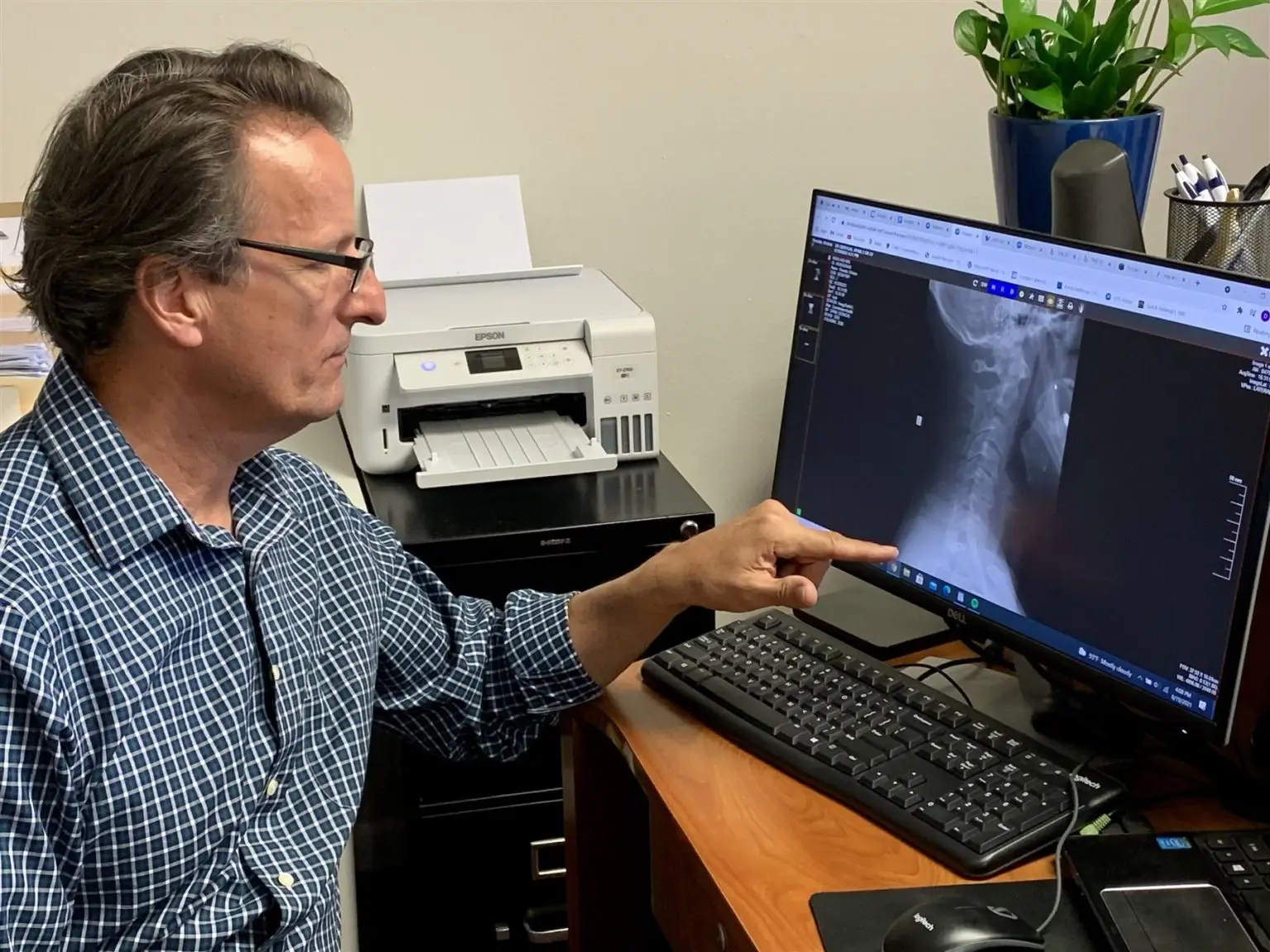 Dr. Dean Hegarty reviewing a patient’s spine X-ray on the office computer
