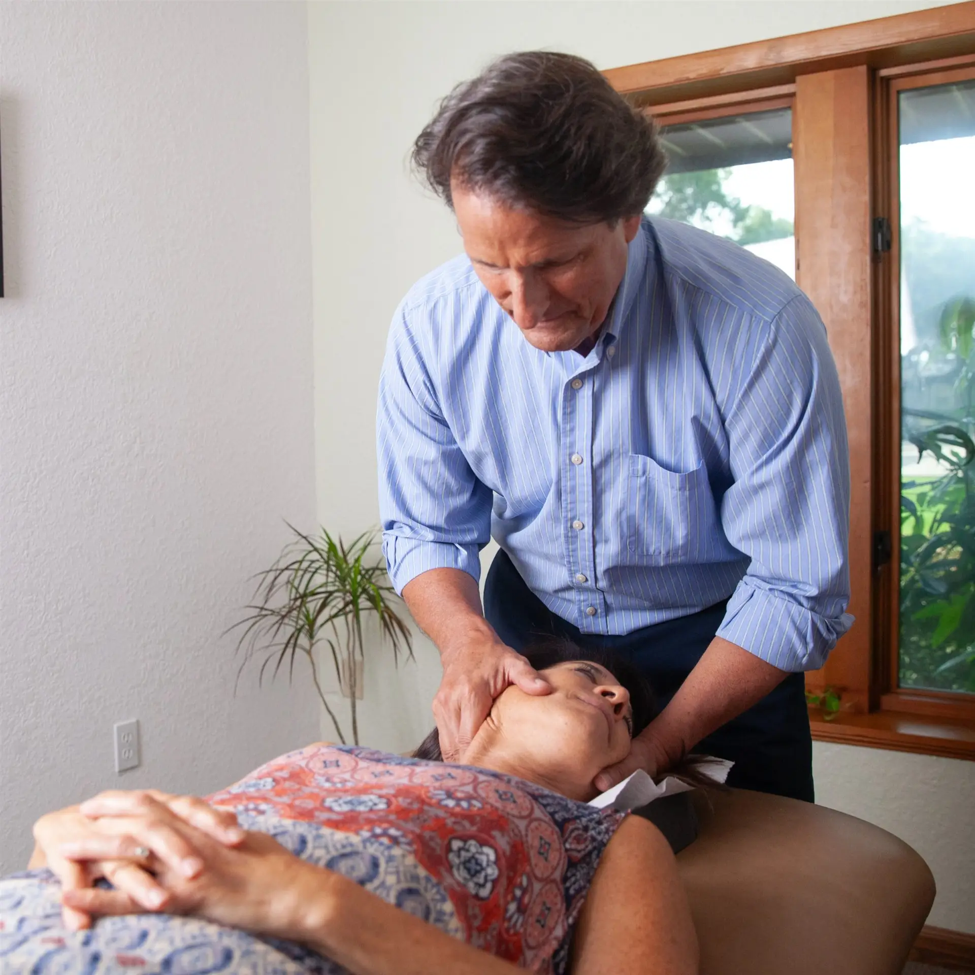 Dr. Dean Hegarty gently adjusting a patient’s neck at Spinal Solutions Chiropractic in Sterling Heights, Michigan