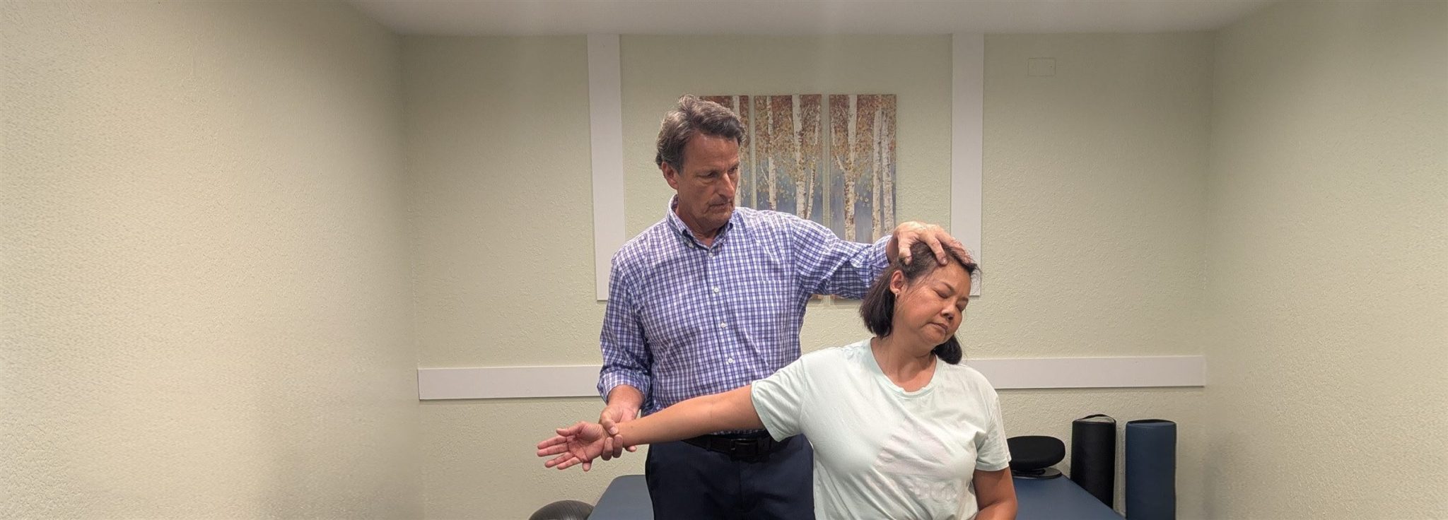 Dr. Dean Hegarty stretching a patient's neck and shoulder in the treatment room